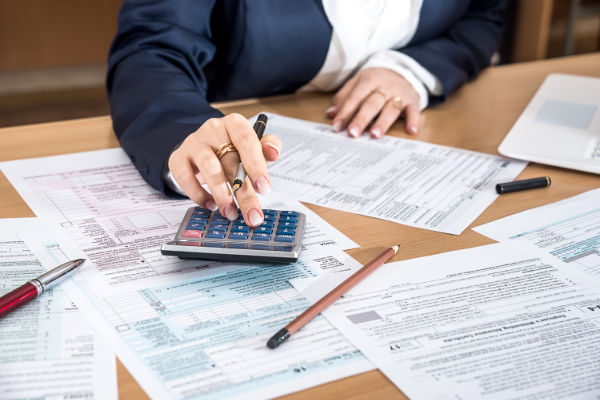 Income Tax Preparer filling out 1040 tax forms for a client.