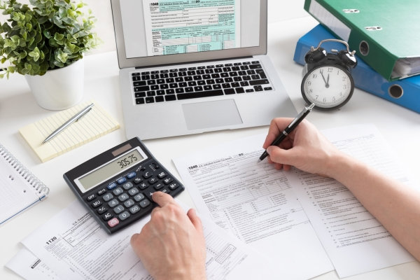 Person filling out Form 1040 to prepare their US federal income tax return before the April 15 due date.