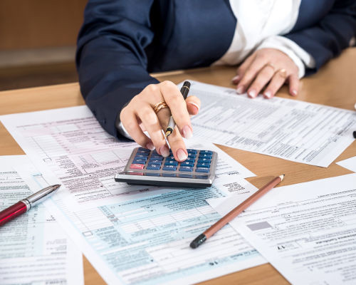 A tax professional preparing IRS Form 1040 and the required schedules for an individual income tax return.